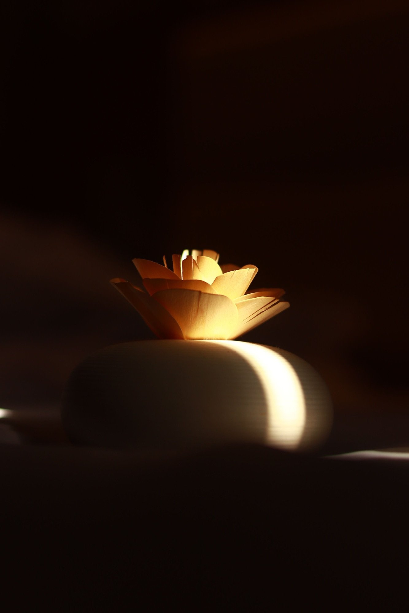Lumière chaude de bougie sur fond sombre, ambiance apaisante du soir